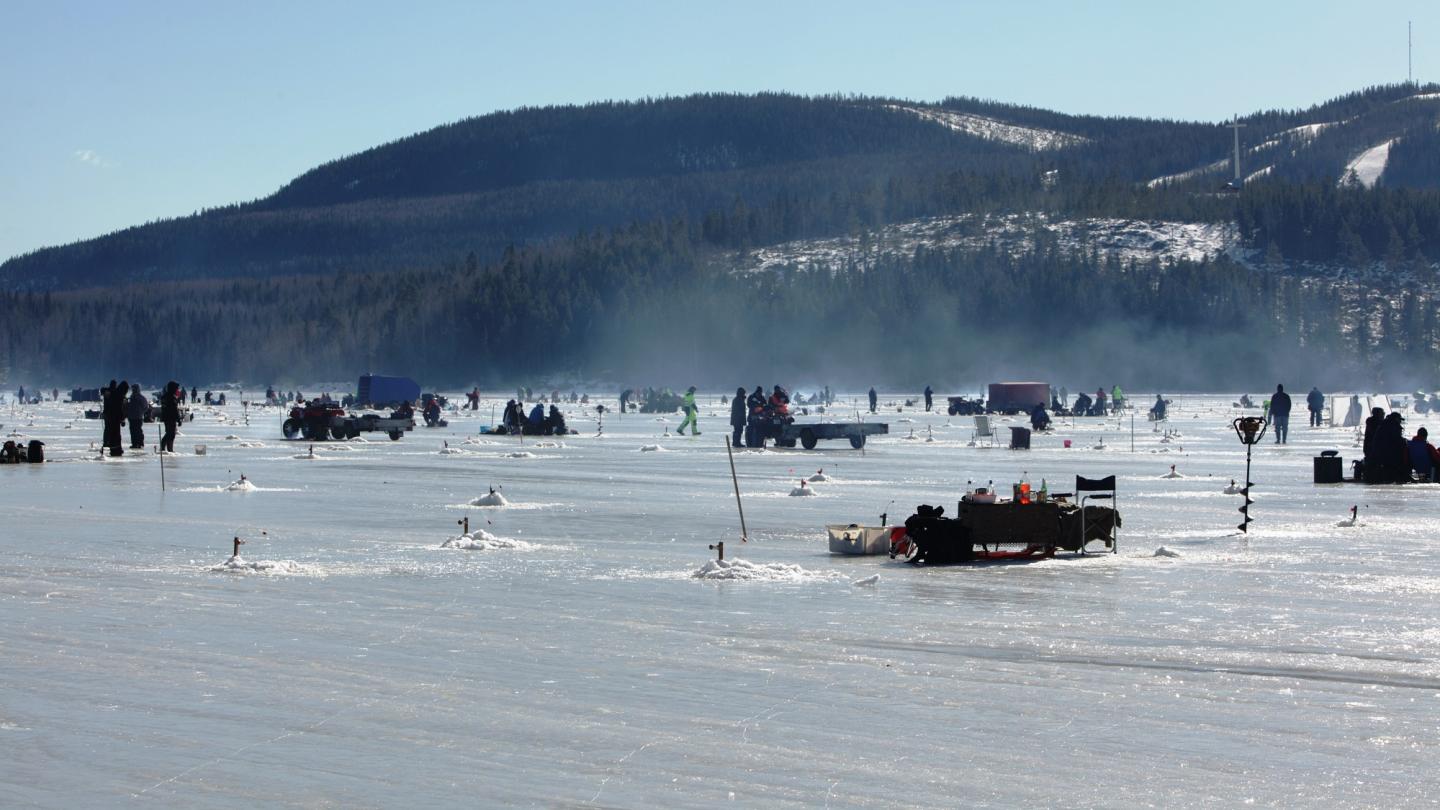 Människor ute på istäckt sjö med angeldon och fiskar.