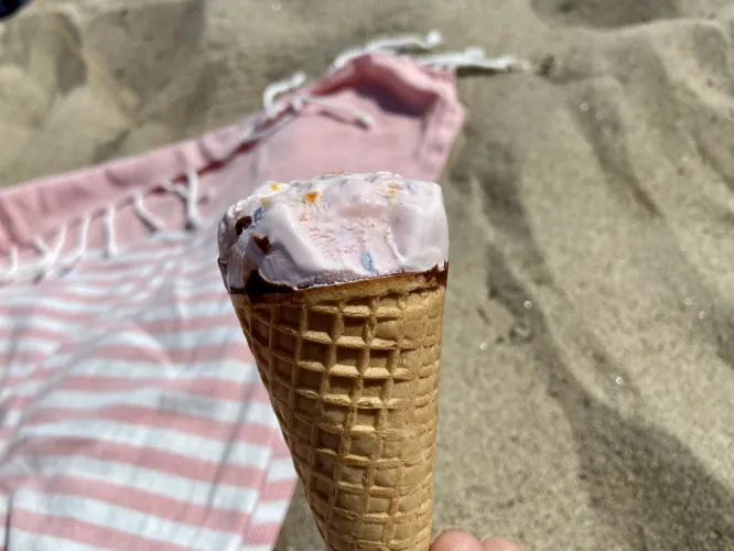 Färgbild - en glasstrut i närbild sandstrand i bakgrunden