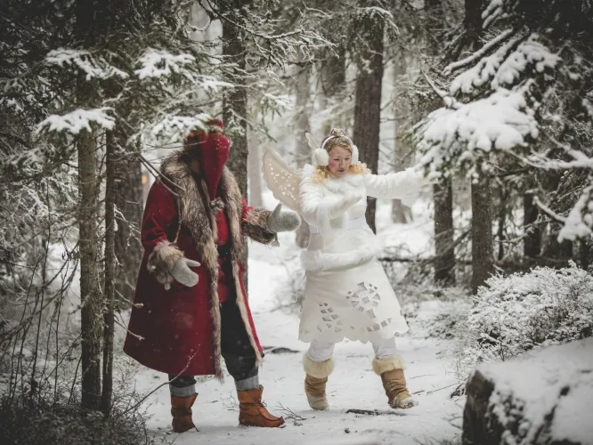 Färgbild - vinter i trolsk skogsmiljö med en tomte och älva mitt i bild