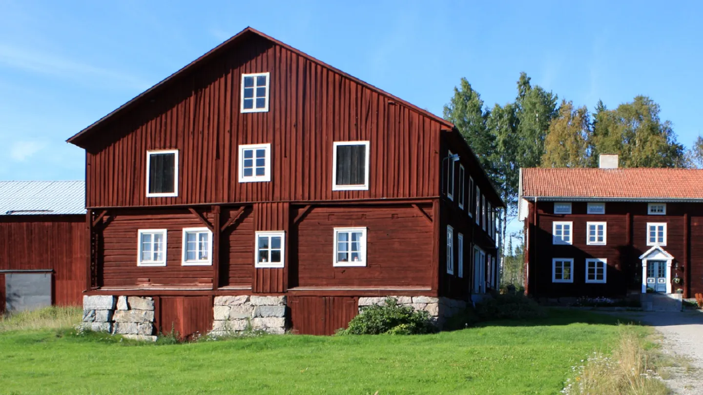 Röda byggnader med vita knutar i klassisk hälsingegårdsstil