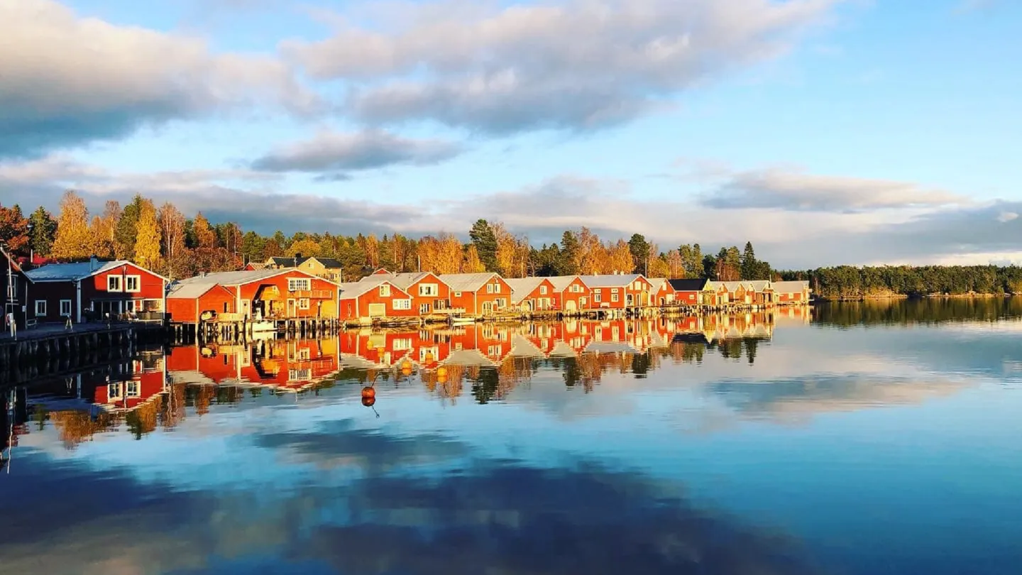 Färgbild - drönarvy över sjöbodar längs kustorten Mellanfjärden och havet i förgrunden