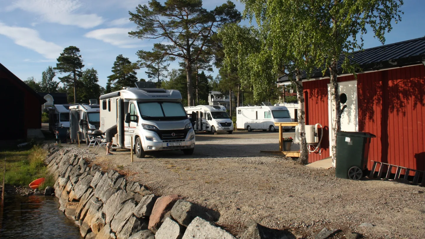 Stocka hamn och ställplatser - husbilar på rad med rött servicehus till höger.